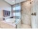 Elegant bathroom featuring an oval soaking tub and a glass enclosed shower with tile surround at 29 Sun Mirage Ave, Henderson, NV 89011