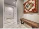 Inviting hallway with wood-look tile, stylish bench, and decorative wall hanging at 29 Sun Mirage Ave, Henderson, NV 89011