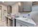 Well-lit laundry room with gray cabinets, modern washer and dryer, and white countertop with sink at 29 Sun Mirage Ave, Henderson, NV 89011