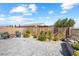 Charming backyard with paved patio, privacy wall, manicured shrubs, flowering plants, and comfortable seating area at 3543 E Wallowa Dr, Pahrump, NV 89061