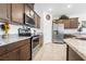Kitchen with stainless steel refrigerator and oven with dark cabinets and granite countertops at 3543 E Wallowa Dr, Pahrump, NV 89061