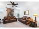 Inviting living room with ceiling fan, neutral carpet, and brown sofas paired with elegant side tables and lamps at 3543 E Wallowa Dr, Pahrump, NV 89061