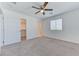 Inviting bedroom with neutral carpet, ceiling fan, and ensuite bathroom access at 3634 Tripoli Cove Ave, Las Vegas, NV 89106