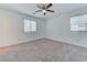 Spacious bedroom offers neutral carpet, modern ceiling fan, and natural light from two windows at 3634 Tripoli Cove Ave, Las Vegas, NV 89106