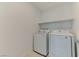 Bright laundry room with a side-by-side washer and dryer and a white shelf at 3634 Tripoli Cove Ave, Las Vegas, NV 89106