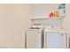 Laundry room with washer, dryer, and overhead shelving at 3634 Tripoli Cove Ave, Las Vegas, NV 89106