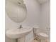 Powder room offers a pedestal sink, a round mirror, and a toilet at 3634 Tripoli Cove Ave, Las Vegas, NV 89106