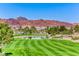 Expansive green golf course with a tranquil pond and mountain views under a clear blue sky at 453 Via Palermo Dr, Henderson, NV 89011