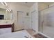 Bathroom featuring a dual sink vanity, framed mirror, large soaking tub, and a glass-enclosed shower at 5805 Hannah Brook St, North Las Vegas, NV 89081