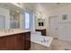 Bright bathroom with dual vanities, a bathtub, tile floors, and a separate shower stall at 5805 Hannah Brook St, North Las Vegas, NV 89081