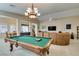 Entertaining game room featuring a pool table, neutral walls, tile flooring, and a stylish chandelier at 5805 Hannah Brook St, North Las Vegas, NV 89081