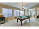 Spacious game room features a classic pool table and a decorative chandelier, perfect for entertaining guests at 5805 Hannah Brook St, North Las Vegas, NV 89081