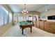 Open game room with a pool table, tile flooring, and a comfortable seating area for relaxation and entertainment at 5805 Hannah Brook St, North Las Vegas, NV 89081