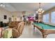 Open-concept living area with a pool table, seating, and access to the adjacent kitchen at 5805 Hannah Brook St, North Las Vegas, NV 89081