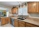 Traditional kitchen features wood cabinets, tile floors, and stainless steel dishwasher at 604 Bryant Ct, Boulder City, NV 89005