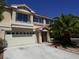 Two-story house with a beige facade, attached garage, and palm trees at 6604 Octave Ave, Las Vegas, NV 89139