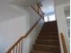 A staircase with carpeted steps leads to the upper level with a wooden handrail and white walls at 6604 Octave Ave, Las Vegas, NV 89139