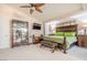 Spacious primary bedroom with a ceiling fan, TV, and an ornate display cabinet at 6632 Blue Hawaii Ave, Las Vegas, NV 89110