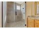 Tiled bathroom featuring tiled walk-in shower with glass door and granite vanity at 670 Du Fort Ave, Henderson, NV 89002