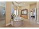 Bright bathroom with a jacuzzi tub, a glass shower, and ample counter space, designed for comfort and luxury at 670 Du Fort Ave, Henderson, NV 89002