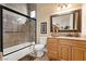 Well-lit bathroom with glass-enclosed shower and granite countertop vanity at 670 Du Fort Ave, Henderson, NV 89002