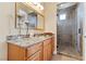 Bathroom vanity with granite countertop, wooden cabinets, a mirror, and walk-in shower at 670 Du Fort Ave, Henderson, NV 89002