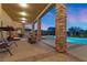 Expansive covered patio with stone pillars overlooking the pool and landscaped backyard at 670 Du Fort Ave, Henderson, NV 89002