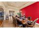 Formal dining room with a large wooden table, seating for eight, and a vibrant red accent wall at 670 Du Fort Ave, Henderson, NV 89002