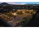 Well lit home exterior with a circular driveway, manicured landscaping, and beautiful desert surroundings at night at 670 Du Fort Ave, Henderson, NV 89002