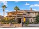 Elegant stone and stucco home featuring a gated entrance, palm trees, and well-manicured landscaping at 670 Du Fort Ave, Henderson, NV 89002