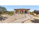 Single story home with desert landscaping, covered porch with stone supports, and lighted walkway to front door at 670 Du Fort Ave, Henderson, NV 89002