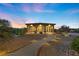 Beautiful, single-story house with lighted walkway and lush landscaping at sunset at 670 Du Fort Ave, Henderson, NV 89002