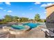 Outdoor pool and spa with natural rock features and well-maintained landscaping under a sunny sky at 670 Du Fort Ave, Henderson, NV 89002