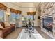 Bright sitting room featuring a stone fireplace, comfortable seating, and elegant decor for a cozy and stylish space at 670 Du Fort Ave, Henderson, NV 89002