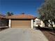 Tan one-story house with a brown garage door and mature landscaping at 7588 Kalmalii Ave, Las Vegas, NV 89147