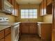 Bright kitchen with wood cabinets, white appliances, and tile flooring at 7588 Kalmalii Ave, Las Vegas, NV 89147