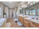 This bathroom includes a double sink vanity, a large mirror, a soaking tub, and a glass shower at 7936 Tolberts Mill Dr, Las Vegas, NV 89131
