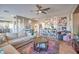 Inviting living room with a cozy seating area, ceiling fan and colorful decorative artwork at 7936 Tolberts Mill Dr, Las Vegas, NV 89131