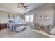 This stylish bedroom is well-lit by a window and features neutral walls, a ceiling fan, and two sitting chairs at 7936 Tolberts Mill Dr, Las Vegas, NV 89131