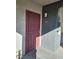 View of secured front door with security gate, address number, wall light, and grey exterior walls at 8600 W Charleston Blvd # 1200, Las Vegas, NV 89117