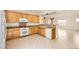 Well-lit kitchen featuring wood cabinets, tile floors, a white dishwasher, and an open concept layout at 8633 Sherwood Park Dr, Las Vegas, NV 89131