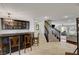 Home bar with seating and staircase to upper level at 8870 S Tenaya Way, Las Vegas, NV 89113