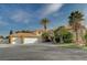 Two-story house with three-car garage, landscaping, and palm trees at 8870 S Tenaya Way, Las Vegas, NV 89113