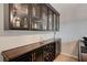 Custom home bar with glass-front cabinets and a wine rack at 8870 S Tenaya Way, Las Vegas, NV 89113