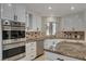 Bright kitchen with double oven, granite countertops, and white cabinets at 8870 S Tenaya Way, Las Vegas, NV 89113