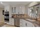 Modern kitchen with white cabinets, granite countertops, and a large sink at 8870 S Tenaya Way, Las Vegas, NV 89113