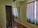 Bedroom featuring a mirrored closet, hardwood floors, green walls, and a window at 9022 Sosa Creek Ave, Las Vegas, NV 89149