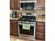 Close up of the oven and range with granite counter tops and wooden cabinets at 9022 Sosa Creek Ave, Las Vegas, NV 89149