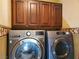 Convenient laundry area featuring modern front load washer and dryer with overhead cabinets at 9022 Sosa Creek Ave, Las Vegas, NV 89149