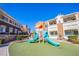 Modern playground with a slide set in a grassy area at 9303 Gilcrease Ave # 2172, Las Vegas, NV 89149